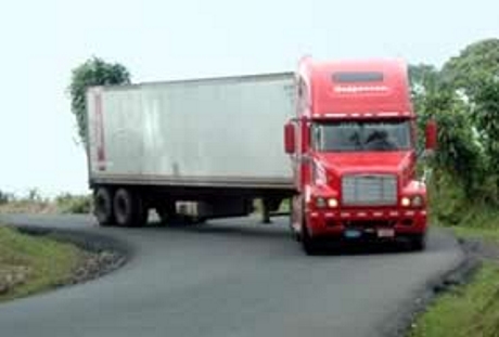 Truck handles curve on road by taking both sides of highway